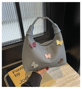 Dettaglio della borsa grigia in tela con farfalle 3D colorate e manico in pelle