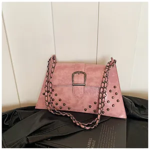 Detail der rosa Kunstledertasche mit schwarzen Nieten, großer Metallschnalle und Kette