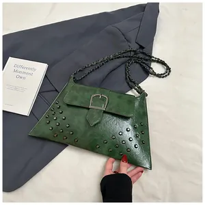 Detail der grünen Vintage-Tasche aus Ölwachsleder mit Metallschnallen und Silbernieten