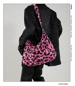 Detail of pink leopard print woven tote bag showing the wide strap and texture on shoulder