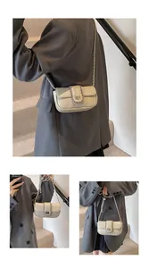Dettaglio della borsa beige a tracolla con catena d'argento e chiusura a girello in metallo