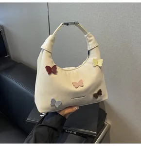 Dettaglio della borsa in tela crema con farfalle 3D colorate e fibbia di chiusura in metallo