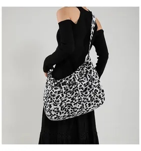 Detail of high-capacity tote bag with leopard print woven texture and shoulder strap