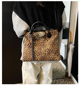 Detail der Leopard-Tragetasche mit schwarzem Ledergriff und goldenem Druckknopfverschluss