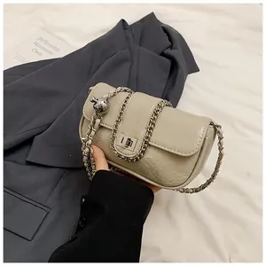 Dettaglio della pelle oliata beige con catena in metallo argento e chiusura rotante