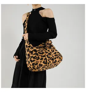 Detailed view of woven leopard print fabric and shoulder strap on large tote bag