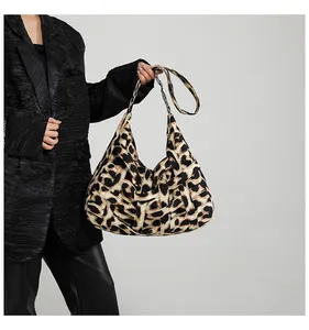 Detail of woven leopard print texture and structured large capacity tote bag on model