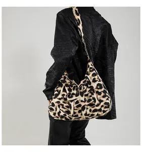 Detail showing the leopard print woven texture and thick shoulder strap of the tote bag