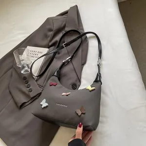 Borsa sottobraccio in tela con farfalle 3D colorate su un blazer e una rivista