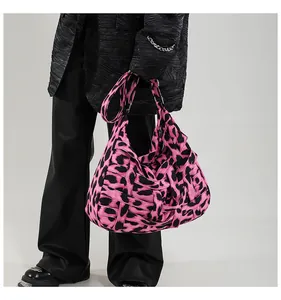 Close-up of pink and black leopard print woven fabric texture on a large hobo bag