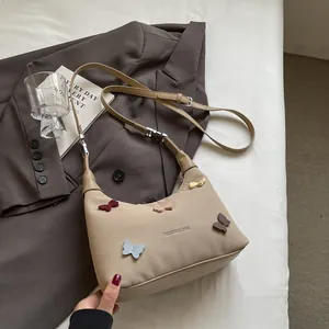Borsa a tracolla in tela beige con applicazioni di farfalle colorate e scritte moda