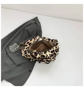 Detail shot of leopard print woven tote bag featuring a black zipper and beige inner lining
