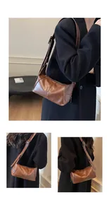 Detail view of brown vintage underarm bag featuring adjustable strap and metallic zippers