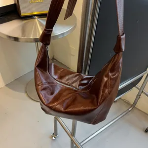 Dunkelbraune Hobo-Tasche aus glänzendem Öl-Wachs-Leder mit Ziernähten und Knoten-Schultergurt