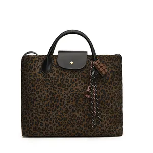 Tragetasche mit Leopardenmuster, schwarzen Ledergriffen und kreativem Schoko-Anhänger
