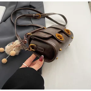 Details einer Vintage Boston-Tasche in Dunkelbraun mit Goldverschluss und Anhänger
