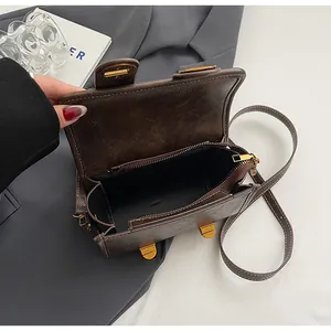 Nahaufnahme der Vintage-Umhängetasche in Braun mit Goldschnalle und feiner Lederstruktur