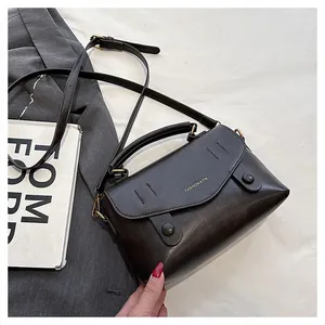 Detailansicht der dunkelbraunen Ledertasche mit Metallschnalle und Schultergurt