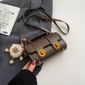 Dunkelbraune Retro-Boston-Tasche aus Leder mit goldenen Schlössern und Plüsch-Anhänger