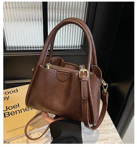Detail of vintage dark brown tote bag showing smooth leather texture and sturdy handle