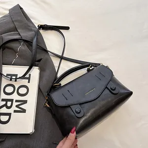 Retro schwarze Tasche mit Goldbeschlägen auf stilvollem weißem Hintergrund