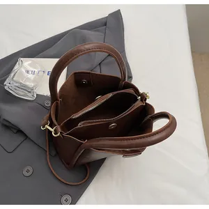 Detail view of deep brown vintage bucket bag showing multi-layer interior and magnetic buckle