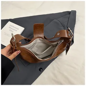Internal view of brown leather shoulder bag with grey lining and zippered pocket