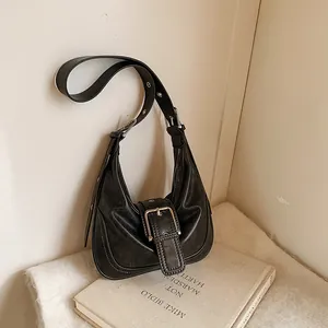 Vintage black oil wax leather crescent shoulder bag with metallic buckle and eyelet strap