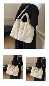 Dettaglio della borsa tote in nylon beige trapuntato con cuciture a onda e coulisse