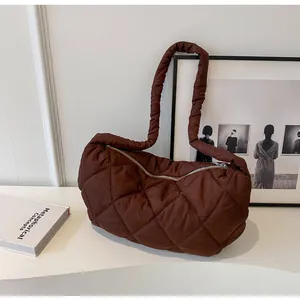 Detailed view of dark brown quilted shoulder bag with ruffles and diamond stitching texture