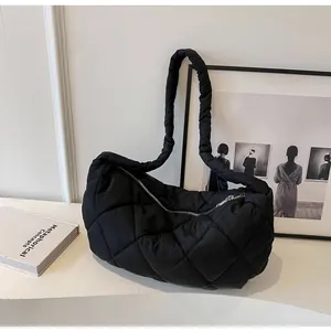 Close-up of black quilted puffer tote bag with waterproof nylon texture and zip closure