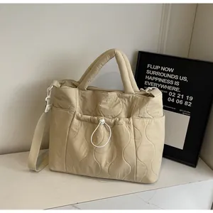 Dettaglio della borsa tote in nylon trapuntato con tasca a coulisse e manico imbottito