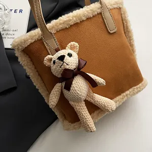 Brown suede bucket bag with beige faux shearling trim and cute plush bear charm