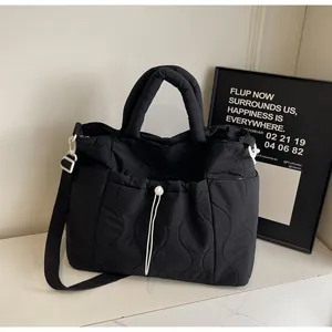 Dettaglio della borsa tote trapuntata nera in nylon con cuciture a onda e coulisse