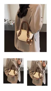 Detail der weichen Leder-Beuteltasche mit Kontrastbesatz und Plüschtier-Anhänger Deko