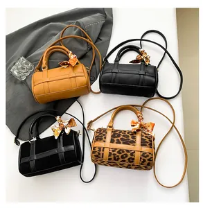 Detail view of four Boston barrel bags in leather, suede, and leopard print with silk scarves