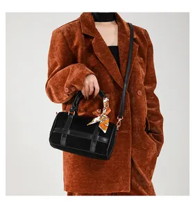 Detail of black Boston bag with suede panels and decorative silk scarf on the handles