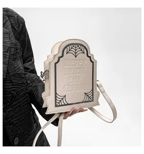 Dettaglio borsa gotica a forma di tomba con ragnatela e scritta Never Trust The Living