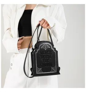 Dettaglio della borsa a forma di tomba con ragnatele e slogan gotico inciso sulla pelle