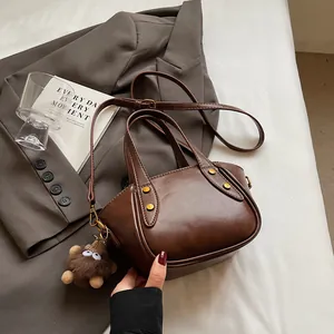 Vintage dunkelbraune Beuteltasche aus weichem Leder mit Plüsch-Anhänger und Schultergurt