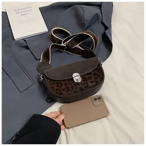 Detail view of the leopard print saddle bag size compared with a smartphone