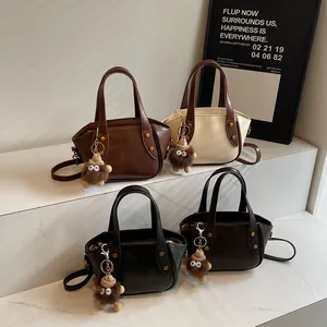 Französische Beuteltasche aus weichem Leder in vier Farben mit Plüsch-Monster-Anhänger