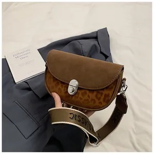Detail of leopard print saddle bag with brown suede flap and silver twist lock buckle