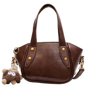 Vintage braune Leder-Beuteltasche mit Goldnieten und niedlichem Plüsch-Anhänger