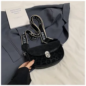 Detail of crossbody saddle bag featuring leopard print panel and classic fashion strap