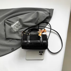 Chic black Boston handbag with matte finish and orange printed silk scarf accent