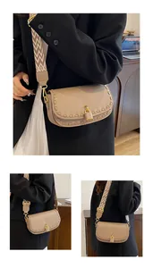 Détail du sac en cuir beige avec bordure tressée, fermoir doré et sangle géométrique