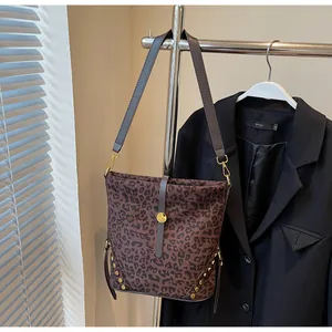 Close-up of leopard print bucket bag with gold clasp and metal rivet detailing