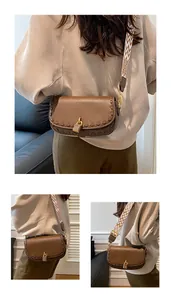 Détail du sac en cuir marron avec bord tressé, fermoir doré et bandoulière géométrique