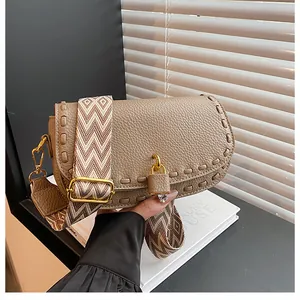 Détail du sac à bandoulière en cuir kaki avec bords tissés et fermoir cadenas doré